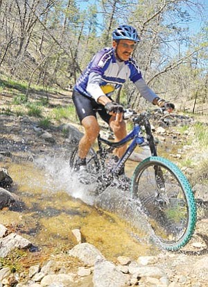 Matt Hinshaw/The Daily Courier<br /><br /><!-- 1upcrlf2 -->Steve Becker rides through a creek on a trail near Thumb Butte Wednesday morning while training for this week’s Whiskey Off-Road mountain bike race in Prescott.  Becker has competed in every Whiskey Off-Road mountain bike race since its inception in 2004.