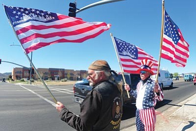 Les Stukenberg/The Daily Courier<br>Curt Boggs, right, a U.S. Navy veteran, and Clay Scott, a U.S. Army veteran, on Monday at the intersection of Glassford Hill Road and Highway 69 in Prescott Valley show their national spirit for the Special Forces' killing of Osama bin Laden. The two veterans received honks and waves of approval from passing drivers who shared their excitement.