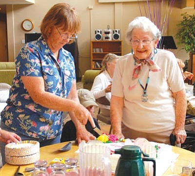 Lisa Irish/The Daily Courier<br>
Beverly Suter cuts a birthday cake for her mother, Florence Wells, at a party to celebrate Florence’s 101st birthday Sunday at The Peridot Senior Residential and Assisted Living Community.