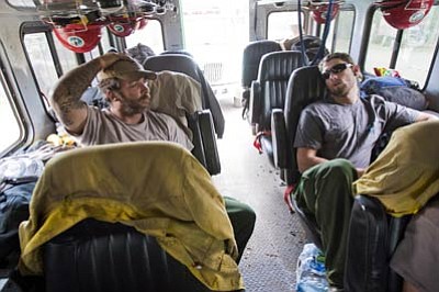 Michael Chow/The Arizona Republic, AP<br>Smith River Hotshots, of Northern California, Joe Russgrove, left, and Forrest Gale relax in their truck at White Mountain Academy in Eager before going back on the line to fight a wildfire Sunday.