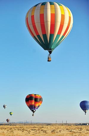 Matt Hinshaw/The Daily Courier<br /><br /><!-- 1upcrlf2 -->Hot air balloons float through the morning sky, kicking off Prescott Valley Days Saturday in front of Tim's Toyota Center.