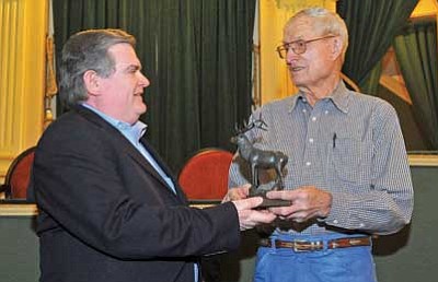 Matt Hinshaw/The Daily Courier<br>
John Olsen, right, chairman of the Elks Opera House Foundation, hands John Sullivan, associate general manager of resource planning for SRP, a miniature statue of Bill the Elk for SRP’s donation of $20,000 to the foundation Thursday afternoon in Prescott.