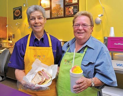 Matt Hinshaw/The Daily Courier<br>
Stephanie Stafford, left, and Toni Nipper, lifelong friends and owners of Dizzy’s Goodie Shop, show off one of their sandwiches and a shaved ice treat Tuesday morning at their shop on Montezuma Street. Dizzy’s Goodie Shop opened its doors this past May.



