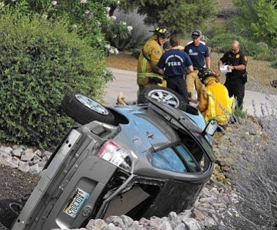 Scott Orr/The Daily Courier<br>Rescue crews prepare to take the victim of a single-car rollover crash to the hospital Thursday morning.