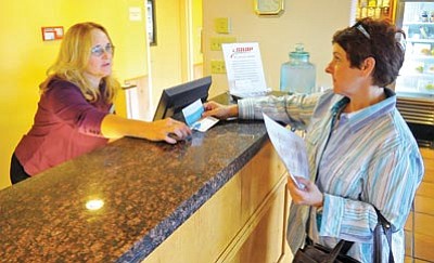 Matt Hinshaw/The Daily Courier<br>Theresa Stalica with Guest Services checks in Robbyn Perez of Tucson at the Marriott SpringHill Suites in downtown Prescott Thursday afternoon.