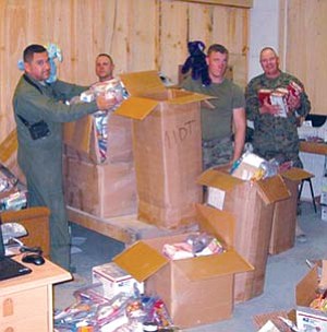 Courtesy photo<br>
U.S. Army Sgt. Major Sam Schmidt sorts through 800 pounds of care packages from Goodies-4-Grunts that he and his men distributed to forward-deployed troops last year.
