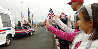 Les Stukenberg/The Daily Courier<br>Emily Robinson, 6, of Prescott Valley waves her flag during the 2011 Veterans Day Parade at Embry-Riddle Aeronautical University Friday in Prescott.