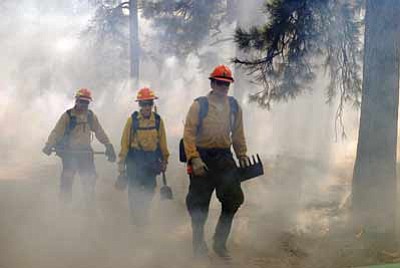 Wildland firefighters walk through the smoke of Horsethief Rx. Holly Krake/USFS