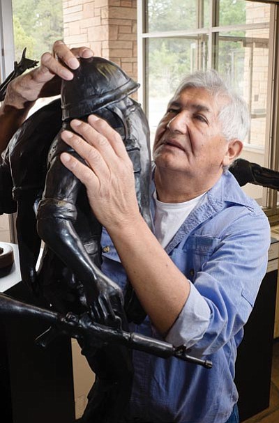 Blind sculptor and South Rim Artist-in-Residence Michael Naranjo touches one of his bronze pieces during his 2014 residency at Grand Canyon. Ryan Williams/WGCN