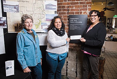 Grand Canyon Coffee and Cafe owner Anna Dick presents a $100 donation to Margaret Hangan and Andrea Dunn with the Williams Historic Photo Project. Dick sells apple pie pieces with real gold flecks to raise money for the project. Ryan Williams/WGCN