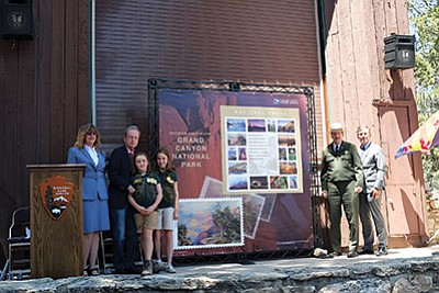 From left: Grand Canyon Postmaster Christine Root, James Bilbray, chairman of the USPS Board of Governors and former U.S. representative of Nevada and grandaughter help Doug Lentz chief of commercial services at Grand Canyon National Park  and Guy Cottrell, chief postal inspector for the USPS reveal a lifesize pane of stamps June 2. Loretta Yerian/WGCN