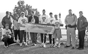 Resident and Special Olympian Bill Barber (third from right) holds the Special Olympic torch, which he ran six and a half miles with the support of local law enforcement officers. The torch was passed to the group at Mather Point and they ran it out to the Tusayan McDonalds, where they were treated to a free breakfast.