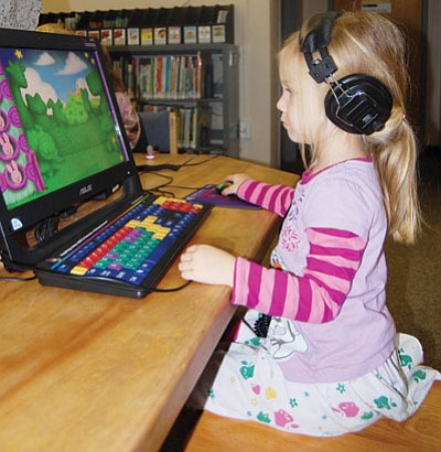 DOUG McMURDO/Miner<BR>
Claire Duley, 4, plays on a computer at the Kingman library earlier this month. The library’s Youth Area has more than 10,000 items available for both children and their parents.
