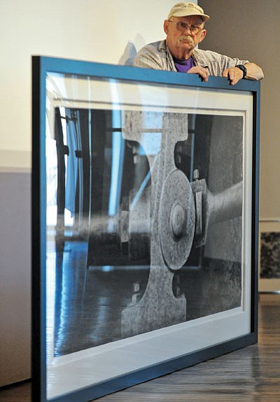 Matt Hinshaw/The Daily Courier<br>

Photographer Jay Dusard stands next to one of his favorite prints, “Steam Engine Crosshead and Pitman, Bodie, California, 2000,” Tuesday afternoon while setting up for his exhibit at the Sam Hill Warehouse in downtown Prescott.