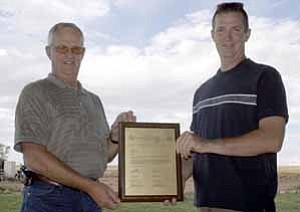 <i>Photo by Jeff Pope</i>
<b>Ken Clay, Jr. (left) holds up the plaque his son, Ken Clay III, was given by his supervisors for being named the Wildlife Manager of the Year for the Arizona Game & Fish Department.</b>