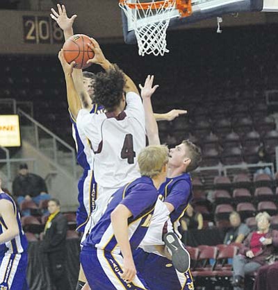 Winslow Bulldog Kraig Shirley (4) goes up for a bucket against several Blue Ridge Yellowjacket defenders during the Arizona State 3A Basketball Tournament held in Prescott. The Bulldogs defeated the Yellowjackets with a final score of 67-57 to advance to the state semi-final playoffs in Glendale.