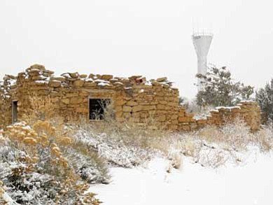 Rosanda Suetopka Thayer/NHO<br>
In a photo taken in 2010 (above), the Y-shaped water tank at Hotevilla Village still stood strong and majestically at the entrance to Hotevilla Village. At left, on final demolition day, dozens of Hopi residents and students from the HBCS stood by as they watch the 53-year-old water tank come crashing to the ground, ending an era of a high visibility landmark for both Hopi and Navajo communities.