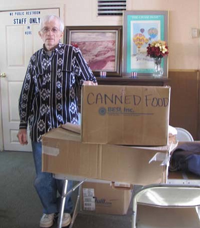 Submited Photo<br>
Paul Gibson, who volunteers at the Grants Community Outreach Center in Grants, N.M., poses with boxes filled with donated non-perishable food delivered by staff members of the Navajo Nation Human Rights Commission.