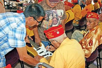 Shonie De La Rosa gets his custom made Navatone guitar signed by a Navajo Code Talker during National Code Talkers Day in Window Rock on Aug. 14. <i>Submitted photo</i>