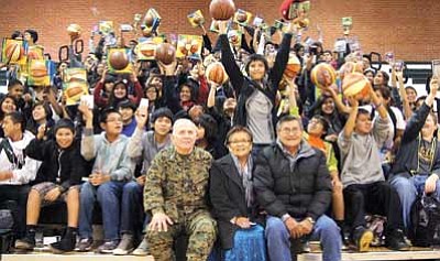 Lt. Col. Peter Tagni (front left) sits with Navajo Nation first lady Martha Shelly and Navajo President Ben Shelly as eighth grade students from Tuba City Middle School celebrate their gifts from Toys for Tots. Submitted photo