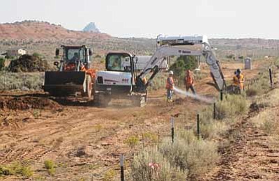 Workers hose down the Cove, Ariz. uranium clean up site to keep dust down. The process of cleaning up the Cove uranium transfer station involved digging up and hauling away tainted soil. Photo/U.S. Environmental Protection Agency