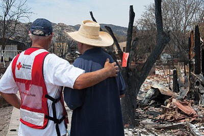 American Red Cross volunteer Marty Martindale gives some encouragement to Yarnell resident Gene Criner, one of scores who lost homes in the wildfire that killed 19 Granite Mountain Hotshot firefighters on June 30. Photo/Todd Tamcsin courtesy American Red Cross