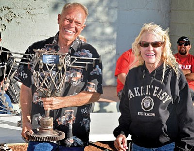 A Winslow couple wins one of the handmade metal art trophies for Best Paint on their car during the 19th annual Just Cruis’n Car Club show Oct. 5. Photo/Todd Roth