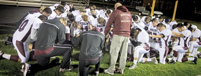 Above: unofficial Chaplan Lou asks for guidance from above for Winslow Bulldogs players and coaches. Todd Roth/NHO
