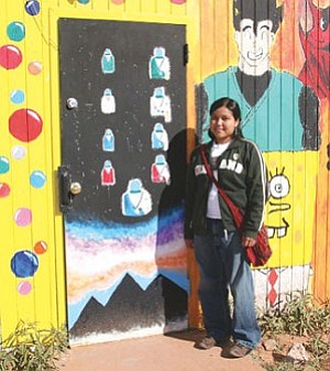 Photo by Byron Poocha
TC High Warrior Varsity Defensive Tackle, award-winning student artist, class president and National Honor Society student Lakota Scott stands beside one of her creations.
