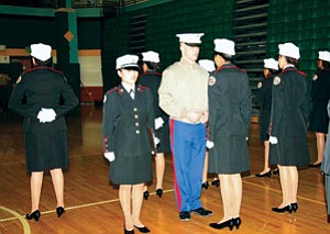 Young female JROTC cadets of the Tuba City High program maintain level eye contact with Marine inspector, Captain St. Croix, who was at Tuba City High school on Friday, December 15th for the annual MJROTC inspection (Photo by Byron Poocha).