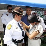 Photo by George Hardeen
Capt. WaunekaÕs daughter Devennie Wauneka pins captains badge on her mother for first time.
