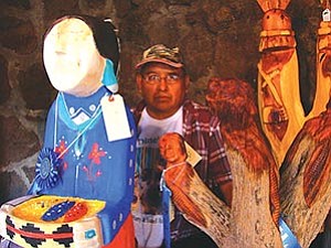 Harry Benally of Sheep Springs, N.M., with two of his “Diné Lady” sculptures. Benally took first place in the Folk Art category with the carving on the left. The carving on the right brought Benally an honorable mention in the sculpture division (Photo by S.J. Wilson/Observer).