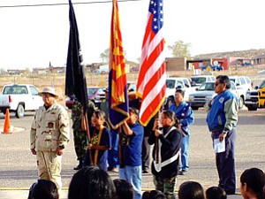 Moencopi Day School students April Austin, Whitney Manygoats and Joyceline Wero, led by Hopi veteran honor guard commander, Gene Talas (Photo by Hookon Mana).
