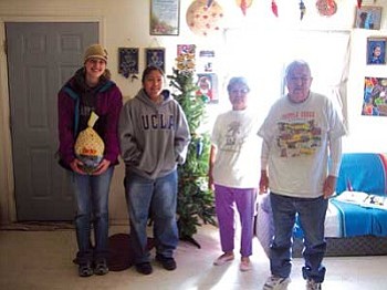 Chantel Benally and Kelly Keith crowded around the Christmas tree with Marian and Sheldon Tallas (Photo by Stan Bindell/NHO).
