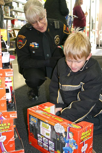 Trib Photo/Sue Tone<br>
Dakota Baughman, 6, of Prescott Valley, stops just inside the Prescott K-Mart store at the stack of toy emergency vehicles similar to the one he arrived in with PVPD Cmdr. Laura Molinaro, his Shop with a Cop partner.