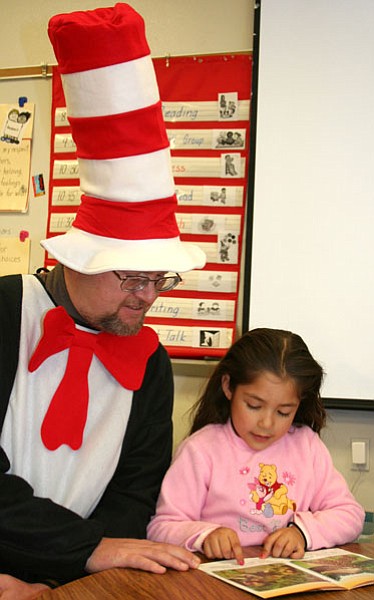 Lake Valley Elementary School Principal Danny Brown, dressed in full Cat in the Hat costume, listens to kindergarten student Maria Gandara read in celebration of Dr. Seuss’ birthday.<br>TribPhoto/Sue Tone