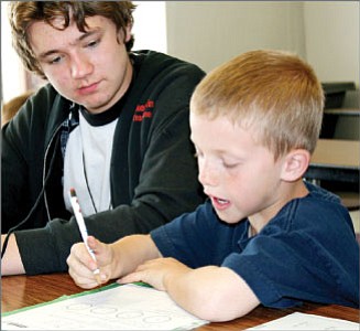 BMHS sophomore Dakota King helps his Little Brother Chris with homework in the Big Brothers Big Sisters afterschool program that matches high school students with Lake Valley Elementary School students.<br>
Trib Photo/Sue Tone