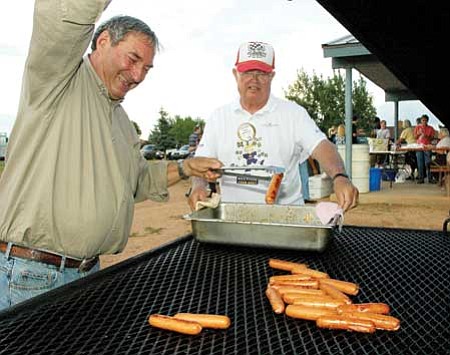 Buzz Fournier and Bob Darnell man the hot dog grill during one of the 2008 National Night Out parties. The community is welcome to join in the festivities this year on Tuesday, Aug. 4.<br>
File Photo/Cheryl Hartz