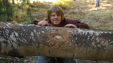 Ethan Hartz peeks over a bearclaw-scarred log on the Mogollon Rim. Photo By Cheryl Hartz