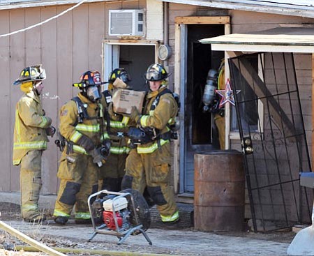 Central Yavapai firefighters remove some of the fire-damaged contents from this converted garage that caught fire Monday afternoon on Kachina Place in Dewey.<br>
Photo courtesy of Les Stukenberg/The Daily Courier