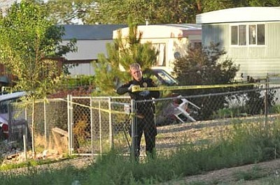 A Prescott Valley Police officer cordons off a home in Castle Canyon Mesa Saturday evening. A friend found two people dead in the home and called police. Yavapai County detectives are investigating the deaths.