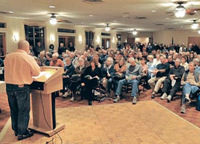 Louie Lizza, a board member of the homeowners association of StoneRidge, talks to more than 200 residents about the pending bankruptcy of SunCor Wednesday night at the StoneRidge Golf Course Clubhouse.<br>
Photo courtesy Matt Hinshaw