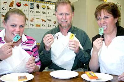 All bibbed up and ready to dine, teachers Kim Grant, left, and David Moore, center, will join Mountain View Elemenatry School Principal Joanne Bindell on April 26 when they will eat larvae, crickets and scorpions at the school’s assembly. Students met Bindell’s challenge to earn 30,000 points by reading books.<br>
Trib Photo/Sue Tone