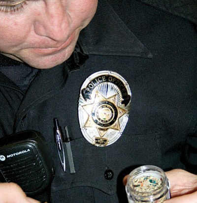 PV Police Officer James Tobin opens a container of Spice, now illegal to possess or use in Arizona.<br>
Trib Photo/Sue Tone