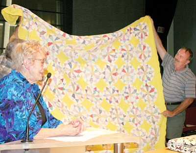 Elsie Gatcomb, 89, appeared before the Prescott Valley Arts and Culture Commission June 20 and showed several of her quilts. This one, held up by Kevin Dey, right, and Lee Power, she made in 1938. “No one told me circles were hard to do,” Gatcomb said.<br>
Trib Photo/Sue Tone