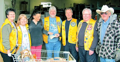 From left, Prescott Valley Early Bird Lions Gloria Grose, Lori Riden, Jeff Riden, Rick Chase, and John Agan make a donation to Ann and Bob Wilson, (third from left and far right) at the Yavapai Food Bank.