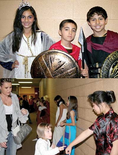 TOP PHOTO: From left, Patricia Estrada presents herself as Iranian Queen Tomyris, ruler of the Massagetae; Zachary Garcia stays in character as King Leonidis of Sparta; and Gabriel Maldonado rules as King Xerxes of Persia.<BR>
BOTTOM PHOTO: Randi-rayne Cupp, 5, presses the “button” on sixth-grader Michelle Tam’s hand to hear the story of Empress Wu, “the most bloodthirsty ruler in China,” during the school’s Wax Museum event on Nov. 5, as Sommer Cupp looks on.<br>
Trib Photos/Sue Tone