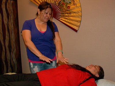 Owner Hope Matsuda demonstrates a Reiki session with Yvonne Franco. Serenity Wellness features many holistic therapies such as this one that utilizes the ancient Japanese form of energy healing.<br>
Trib Photo/Briana Lonas