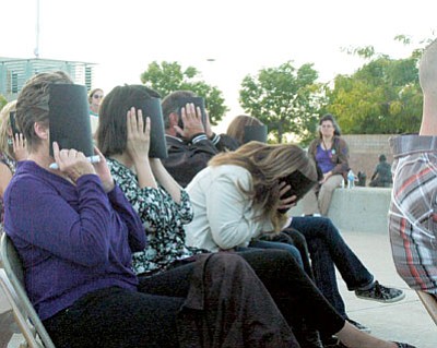 Audience members covered their faces with black paper to represent the darkness victims of domestic violence face when living in abusive situations during the Take Back the Night event at the Civic Center.<br>
Trib Photo/Briana Lonas