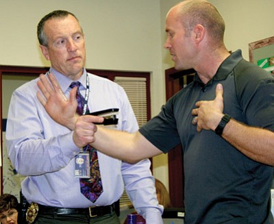 Trib Photo/Sue Tone<br /><br /><!-- 1upcrlf2 -->PVPD Sgt. Scott Stebbins points a "weapon" at Officer Joe McCamish during a demonstration Feb. 25 of one step to take while neutralizing an armed intruder that might come onto the Liberty Traditional School campus. PVPD and the Humboldt Unified School District work closely with teachers and staff on safety plans and situations.